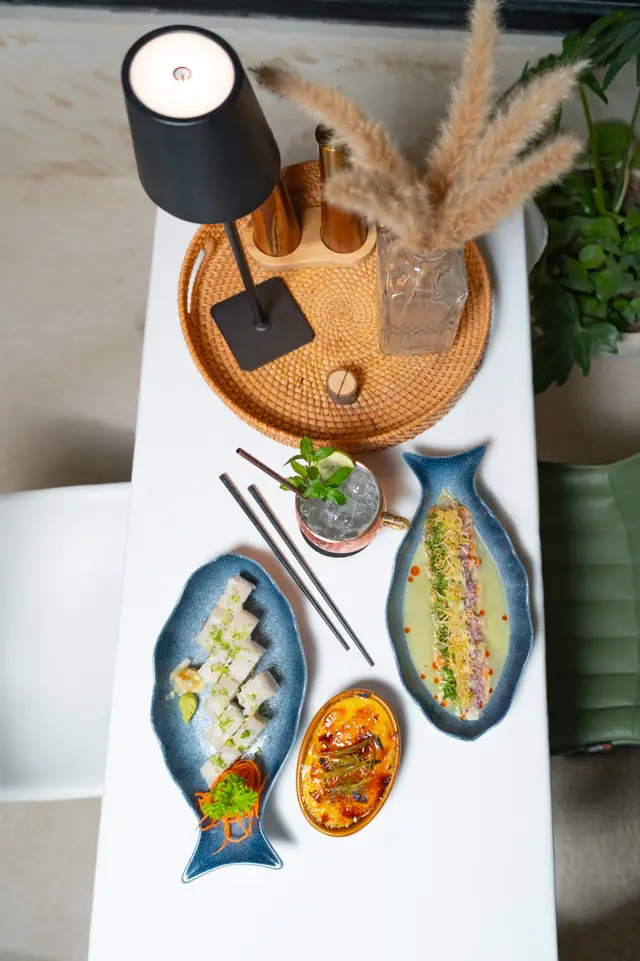 Mesa vista desde arriba con sushi, ceviche, postre y coctel