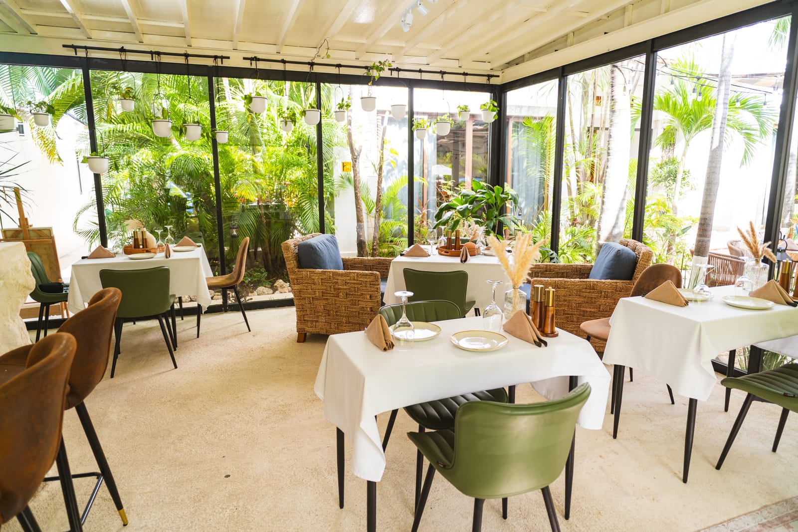 Comedor de cristal de MERO 18 rodeado de jardín selvático en Mezcal Boutique Hotel