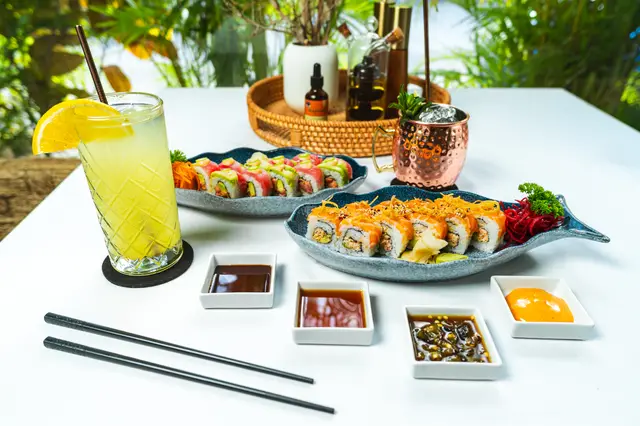 Mesa completa con rollos de sushi de autor, mula de moscú y coctel cítrico en MERO 18 Cancún