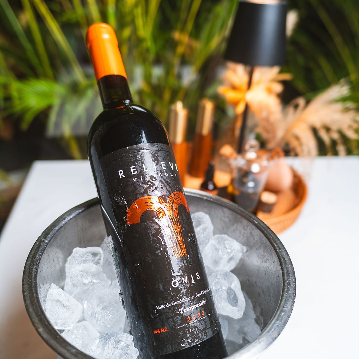 Botella de vino tinto mexicano Relieve Ovis Tempranillo del Valle de Guadalupe enfriándose en una hielera con hielo en MERO 18